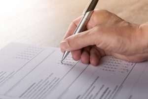 Person using pen taking multiple choice test similar to Qualtrics
