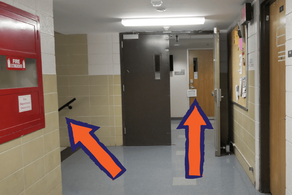 One arrow pointing toward stairs and one arrow pointing towards hallway