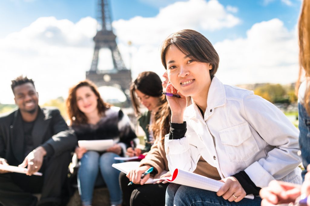 Student smiling with a group of students in front of the Eiffel Tower