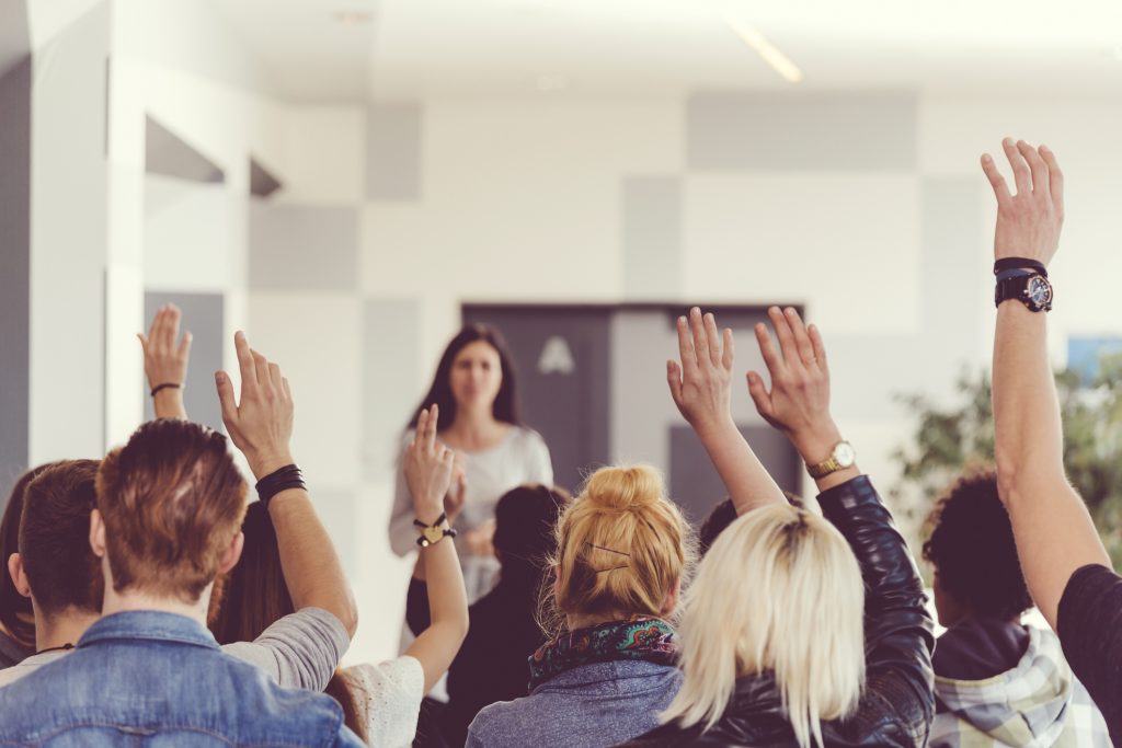 Students raising their hands in a classroom