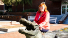 A photo of Jennifer Parker with a gator sculpture. 